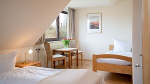 A cozy room with a bed, a desk with a chair, and a window with curtains. - (AMW1) Apartment Garbers/Thiele - Apartment "Garbers/Thiele" to 3 (Timmendorfer Strand)