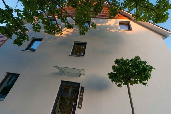 A building with a white facade, multiple windows, and a tree in front. - (STR92) Holiday apartment "Gartenresidenz Strandstraße" - Holiday apartment (Timmendorfer Strand)