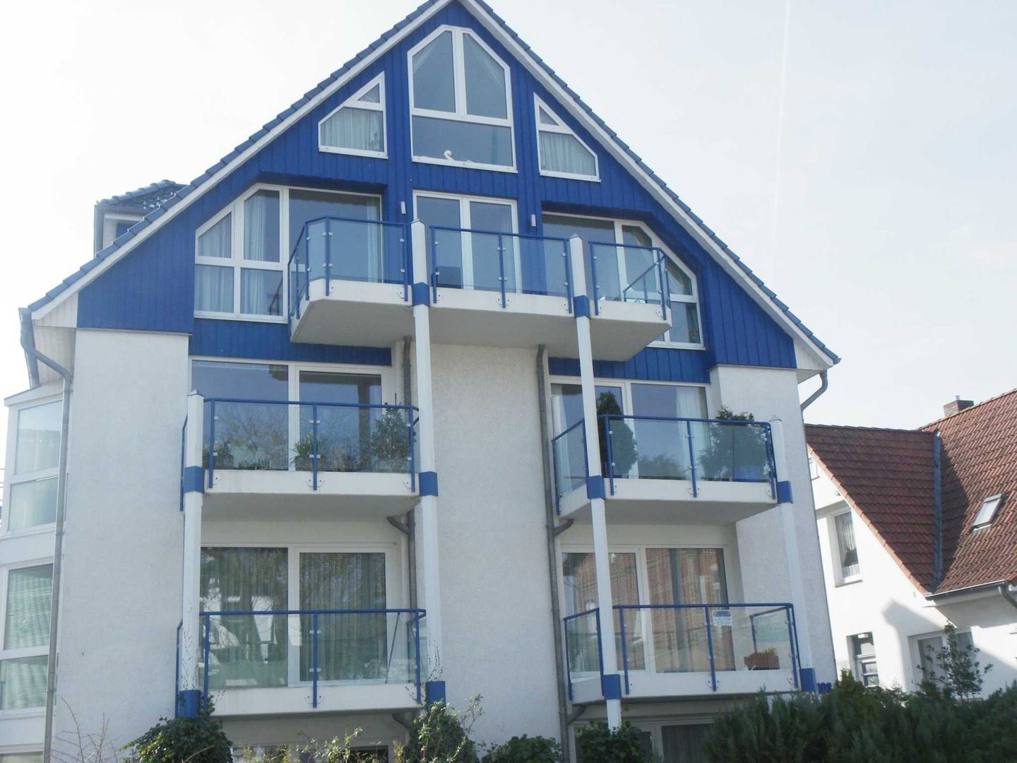 A multi-story residential building with balconies and large windows.