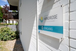 A sign for Windrose Apartments with a logo and the name 'EINGANG' indicating the entrance.