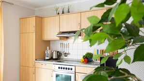 Una cucina moderna con mobili in legno, forno integrato, bollitore e macchina da caffè.