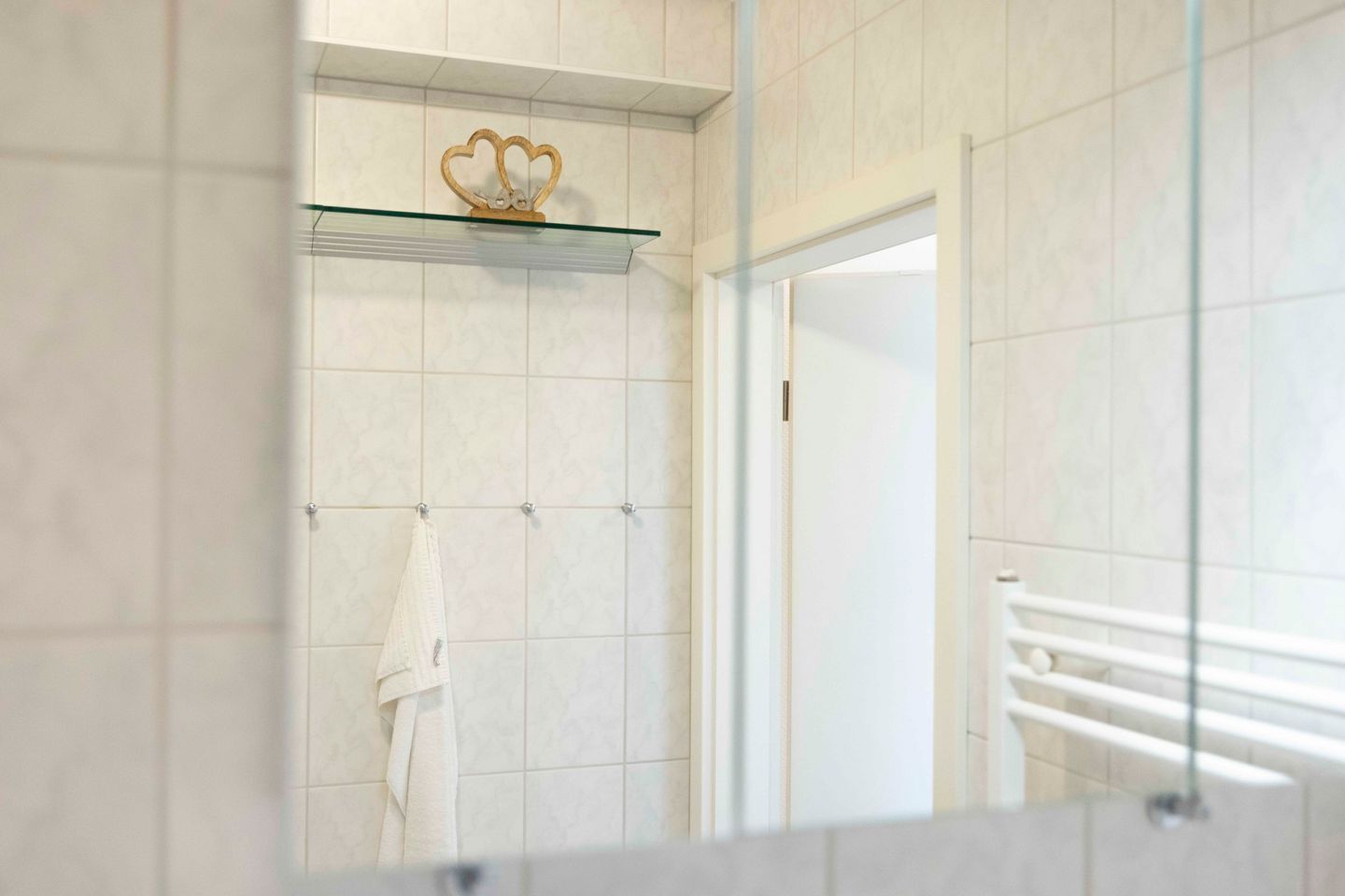 Ein modernes Badezimmer mit einer Glasablage, einem Handtuchhalter und einer Duschkabine.