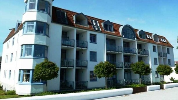 A multi-story hotel with a distinctive corner tower, balconies, and a tiled roof. - (STR123b) Holiday apartment "Strandhotel" - App. 24 - Holiday apartment "Strandhotel" - (Timmendorfer Strand)