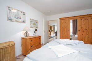 Ein Schlafzimmer mit einem Bett, einem Holzschrank und einer Kommode.