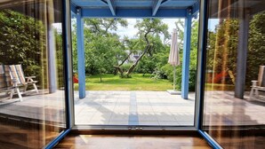 Un interior moderno con un amplio ventanal que da a un jardín exterior.