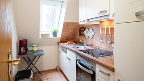 A compact kitchen with a window, a coffee maker, and a sink. - (STR47a) Holiday apartment "Heitmann" - Holiday apartment "Heitmann" up to 4 persons (Timmendorfer Strand)