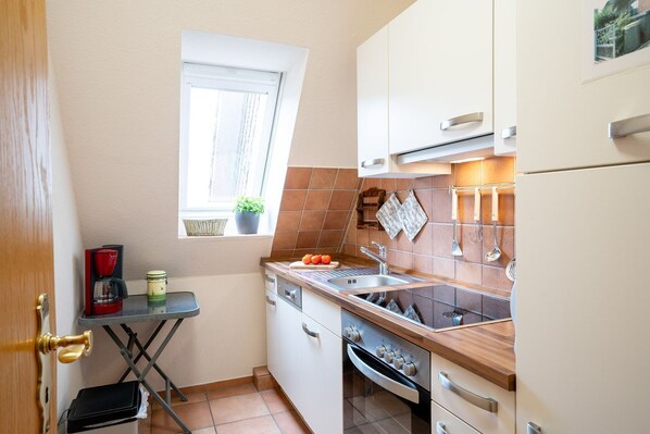 A compact kitchen with a window, a coffee maker, and a sink.