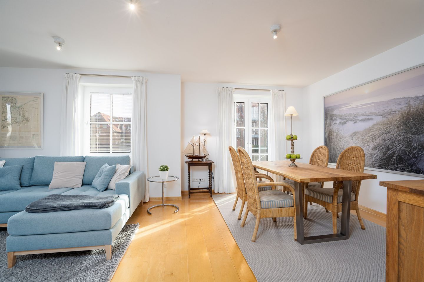 A modern living room with a sofa, dining table, and chairs.