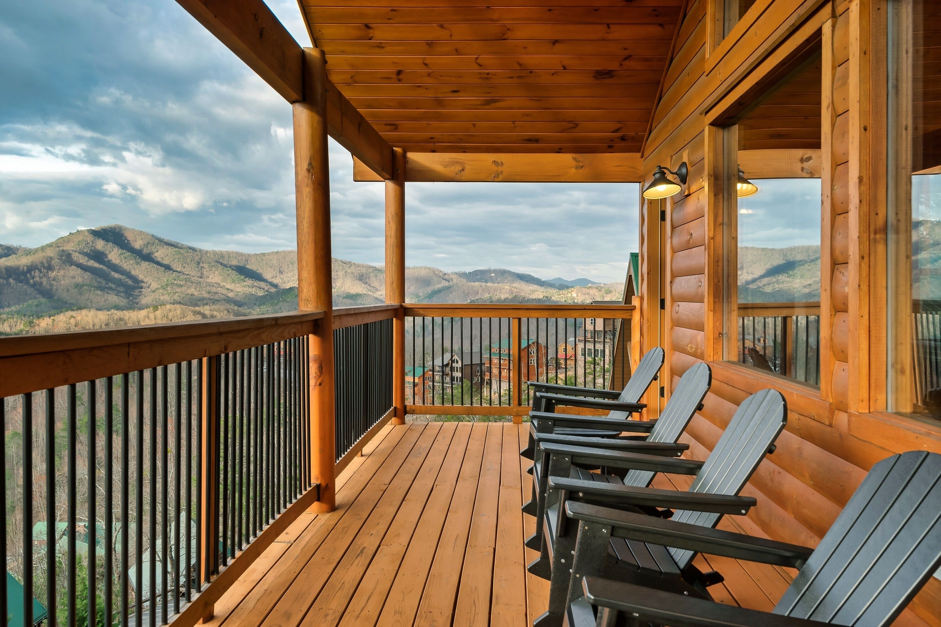 A wooden deck with chairs and a view of mountains.