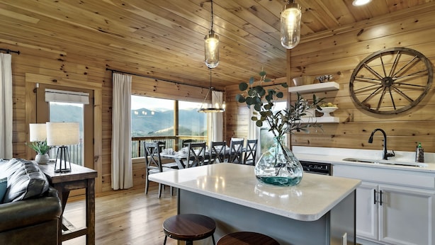 A wooden cabin interior with a kitchen, dining area, and a large window overlooking mountains. - Majestic 3BR Smoky Cabin + Views + Small Pet Friendly + Games + Near Dollywood (Pigeon Forge)