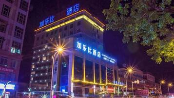 Un hôtel à plusieurs étages, doté d’une enseigne lumineuse, d’une entrée imposante et donnant sur la rue.