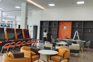 A modern lounge area with seating arrangements, a counter, and a wall with shelves.