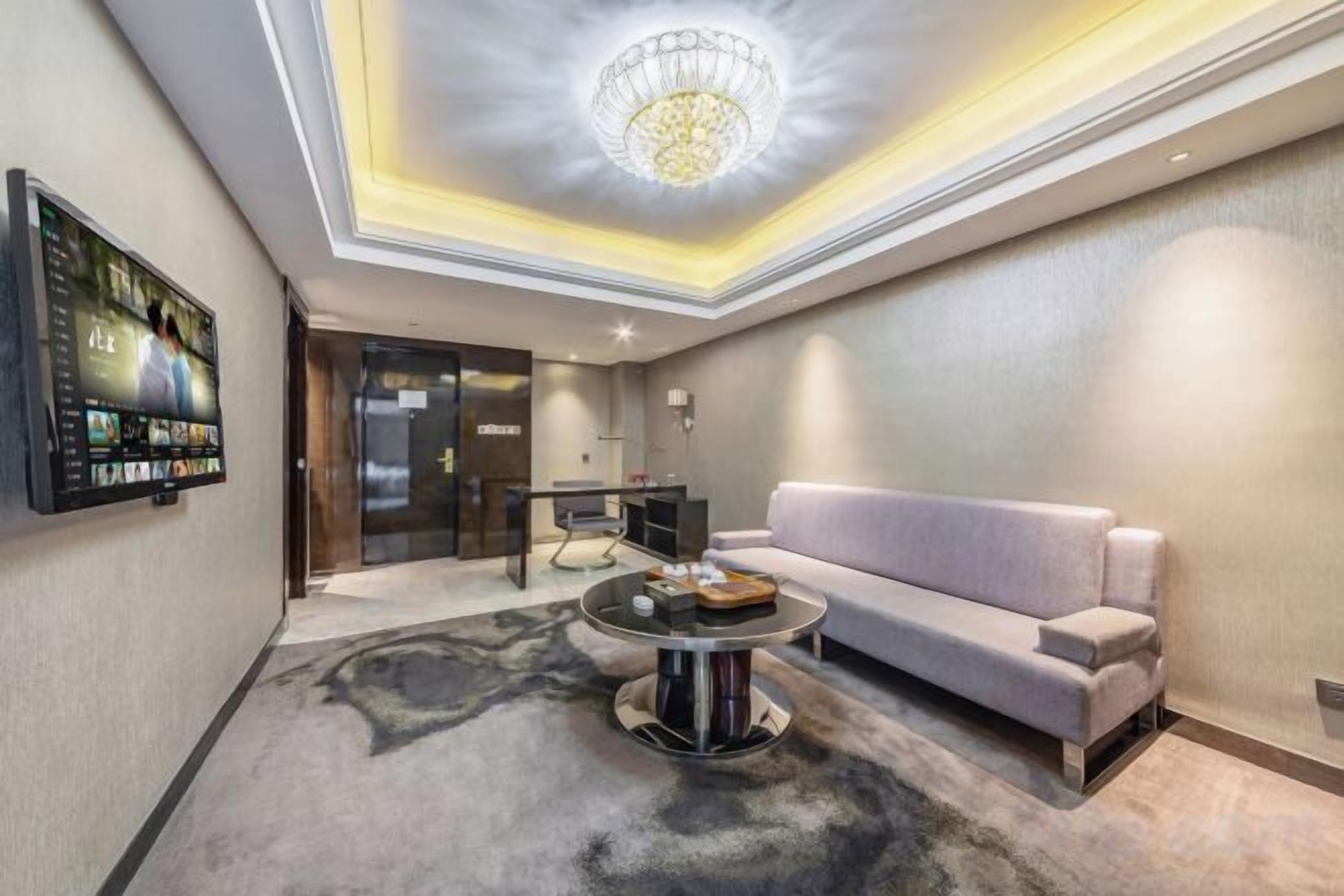 Un salon moderne avec un canapé, une table basse et un téléviseur fixé au mur.