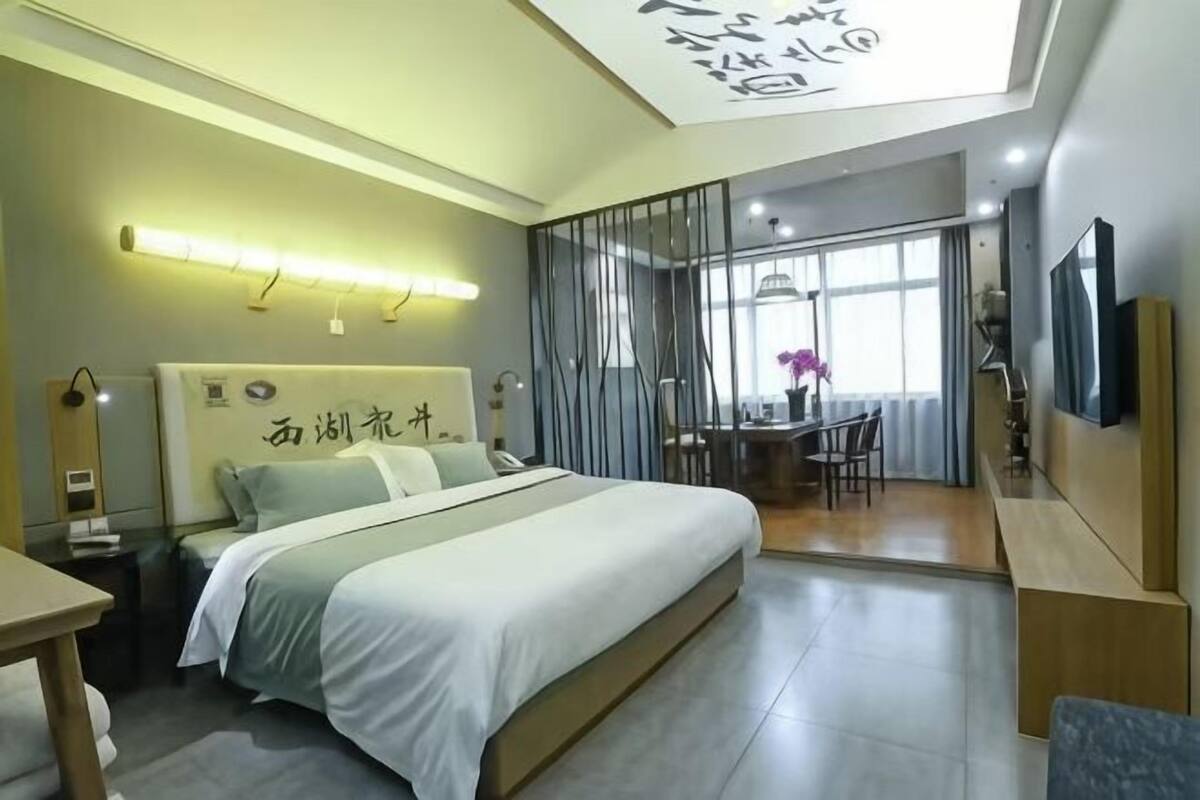 Una habitación de hotel moderna con una cama grande, un escritorio y un rincón comedor.