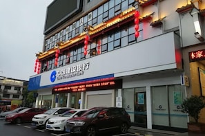 A China Construction Bank building with a signboard, parked cars, and a red lantern decoration. - Yemingju Hotel (Zhuzhou)