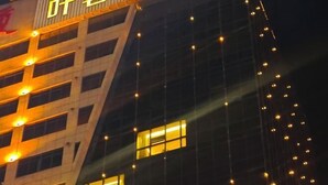 Un edificio con ventanas iluminadas y un cartel con caracteres chinos.