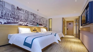 Habitación de hotel con una cama grande, un mural en la pared y un pasillo que conduce a otra habitación.