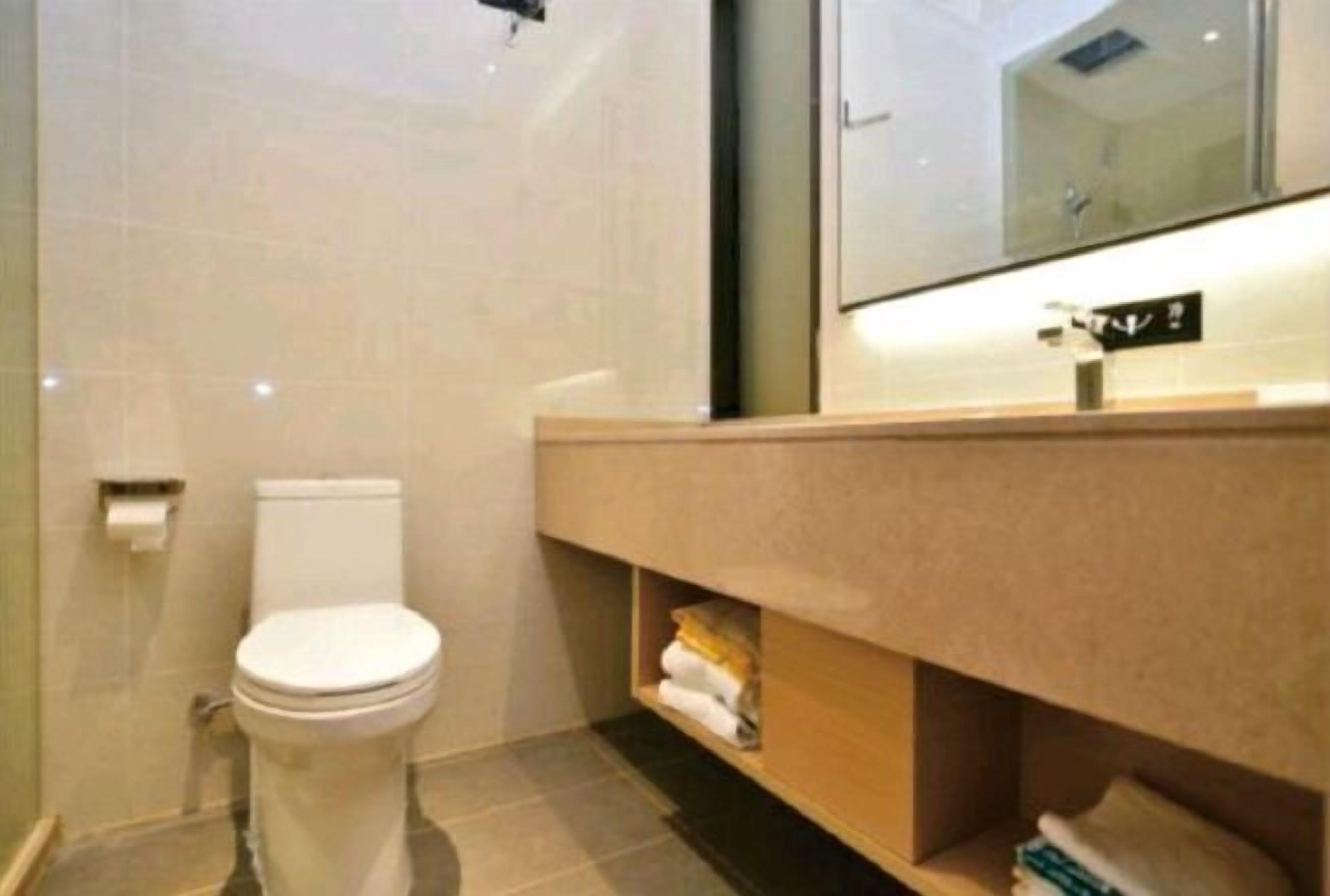 A modern bathroom with a toilet, a sink, and a mirror.