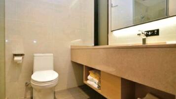 A modern bathroom with a toilet, a sink, and a mirror.