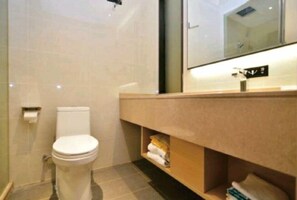 A modern bathroom with a toilet, a sink, and a mirror. - City Convenient Hotel (Yuxi)