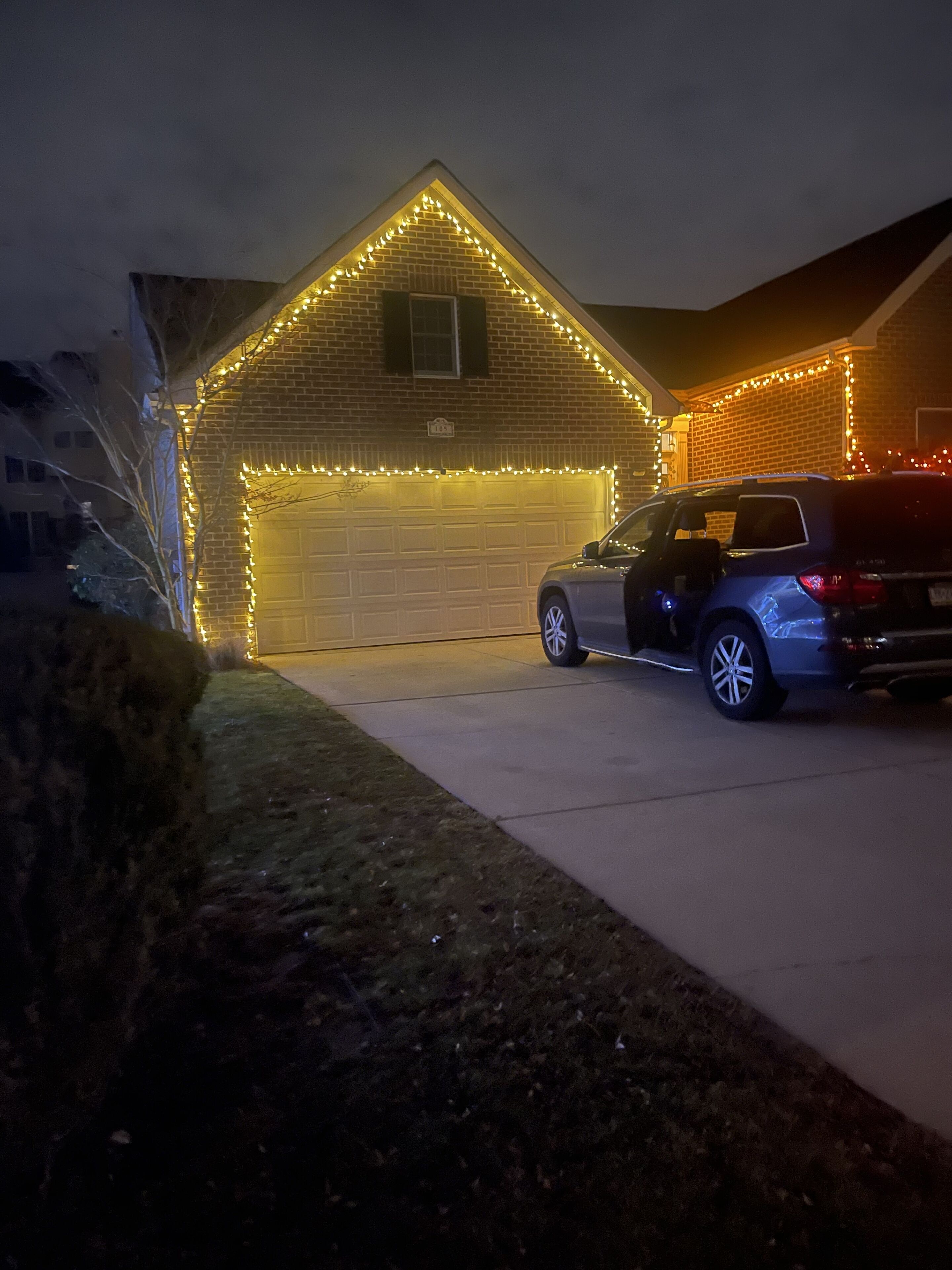 A vehicle parked in front of a building with a garage door and a brick wall.