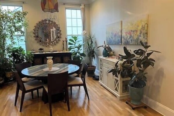 A dining area with a round table, chairs, and potted plants. - 5 BR w/ Band & Piano Setup, Private Gym, Theatre & Office (Cherry Hill)