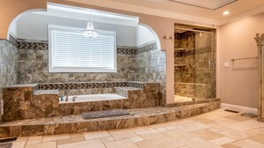 Ein Badezimmer mit einem Waschbecken aus Stein, einer Badewanne und einer Duschkabine aus Glas.