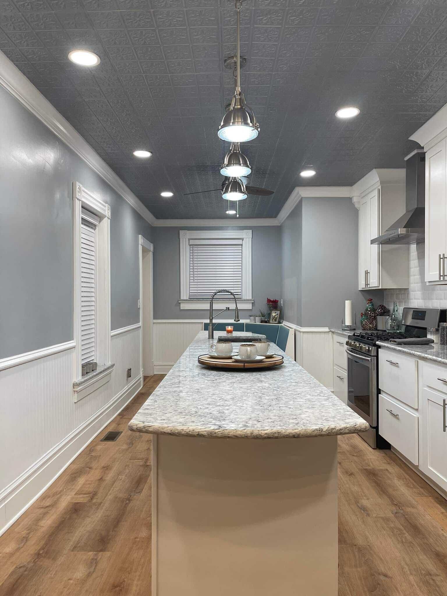 A kitchen with a central island, white cabinetry, a built-in oven, and a ceiling with recessed lighting.