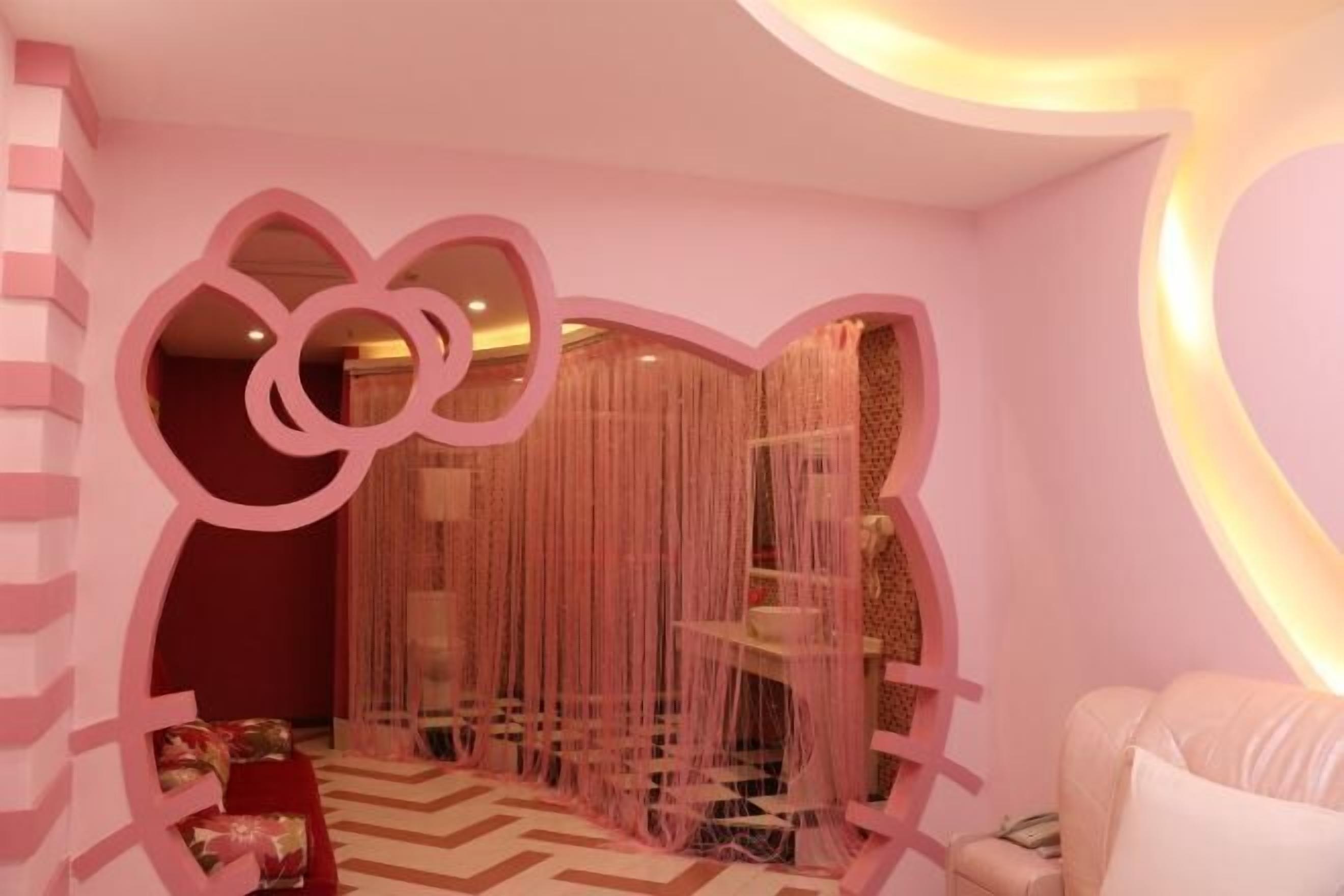 Ein Zimmer mit rosa Farbgestaltung, inklusive einer Wand mit Herzförmigem Ausschnitt und einem Vorhang.