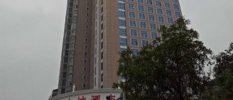 A high-rise building with multiple floors, featuring a prominent sign at the top.