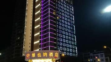 A hotel with illuminated signage and a modern building facade.