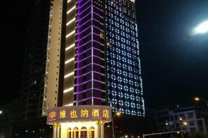 A hotel with illuminated signage and a modern building facade. - Vienna Hotel (Yongzhou District Government Square) (Yongzhou)