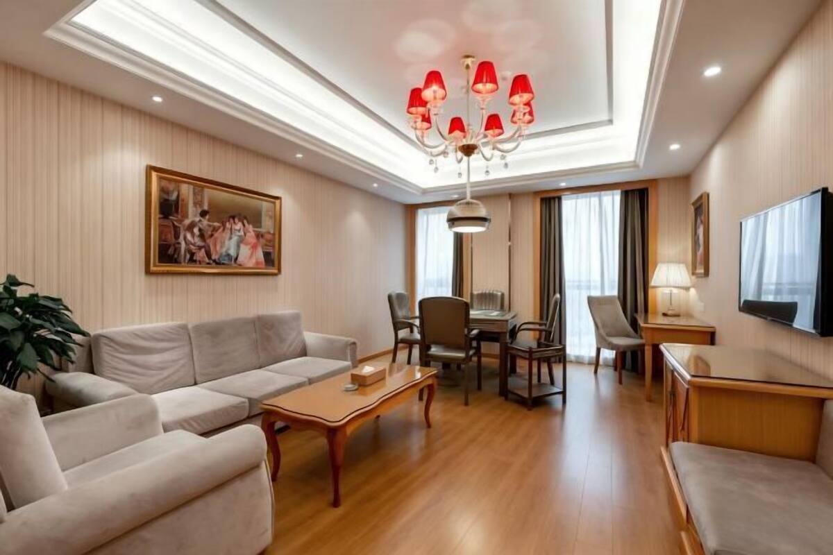A spacious living room with a sofa, coffee table, and TV.