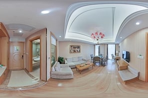 Ein modernes Wohnzimmer mit gewölbter Decke, einer Couch, einem Couchtisch und einem Fernseher.