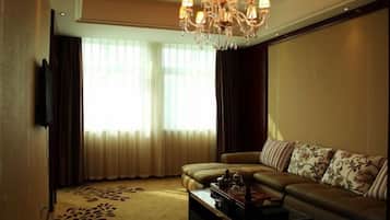 A living room with a sofa, a coffee table, and a chandelier.