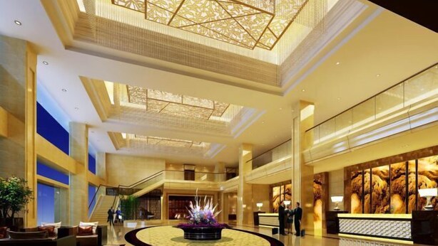 A spacious lobby with a central floral arrangement, a reception desk, and a staircase leading to upper floors. - Donghua Hotel (Zherong)