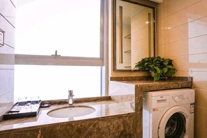 A bathroom with a sink, mirror, and a window. - Kerry Carl Cinema Hotel (Wuhan Optics Valley Technology Convention and Exhibition Center Branch) (Wuhan)