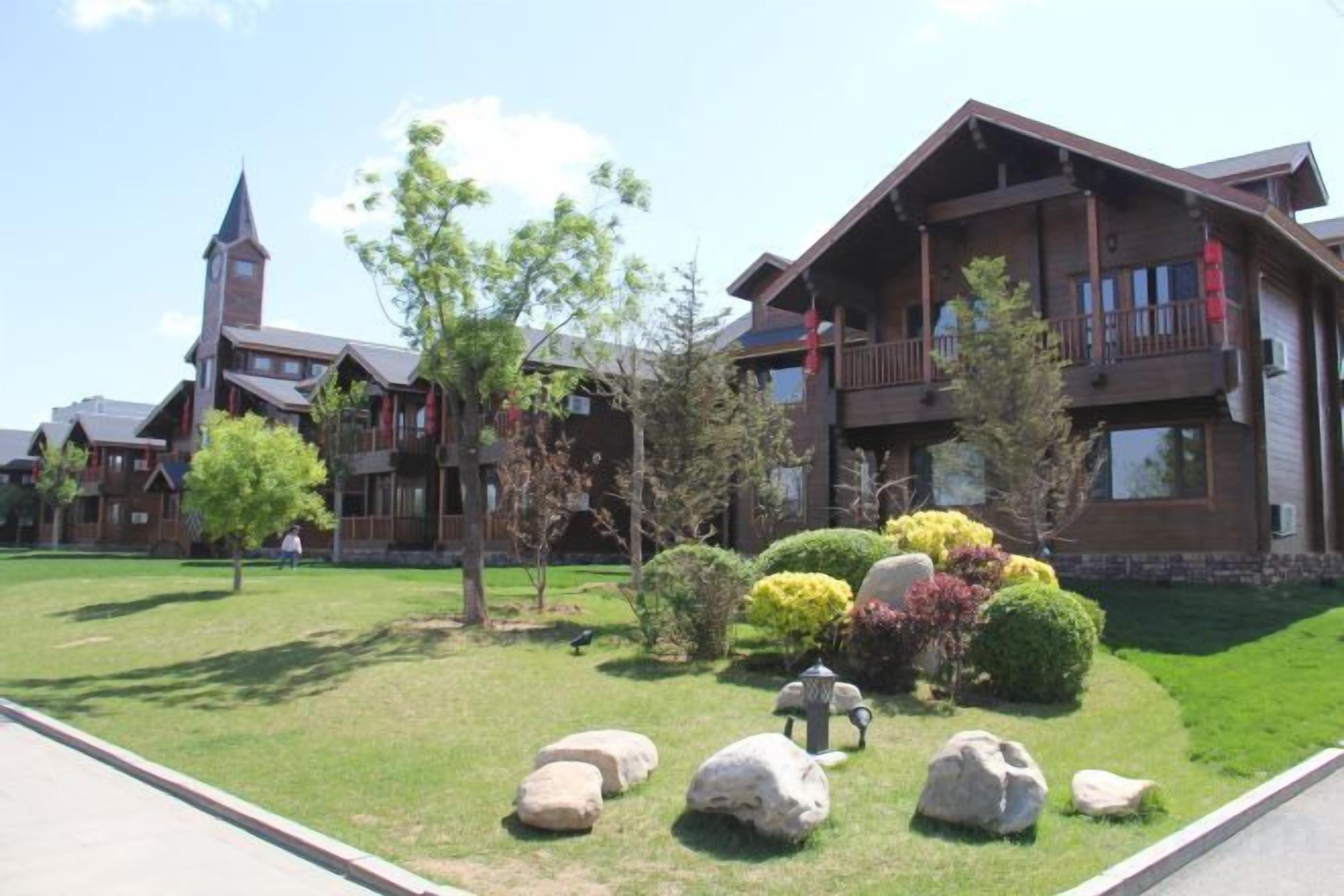 A lodge with a large building, a church, and well-maintained landscaping.