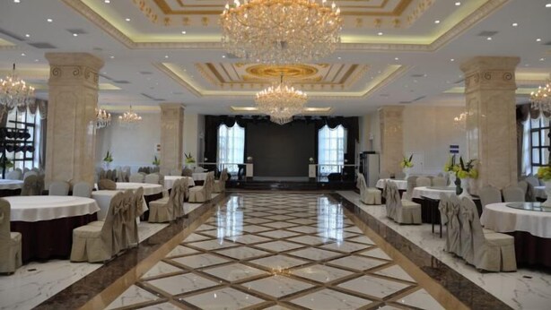 Un amplio salón de banquetes con una larga mesa, candelabros y arquitectura clásica.