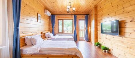 Een houten kamer met twee bedden, een televisie en een groot raam.
