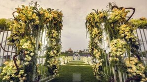 Un pasillo nupcial al aire libre con arcos florales y un diseño circular central.