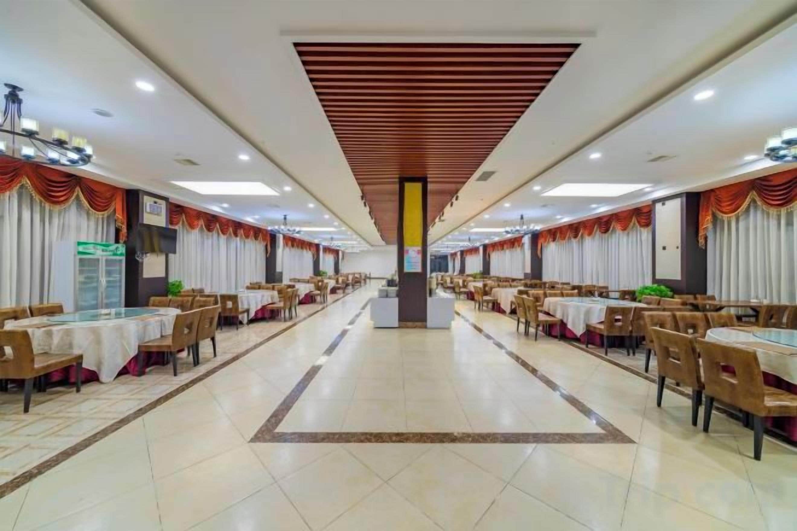 A spacious banquet hall with multiple tables and chairs arranged for dining.
