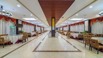 A spacious banquet hall with multiple tables and chairs arranged for dining.