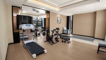 A modern gym with exercise equipment, a treadmill, and a weight bench.