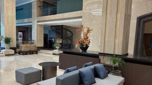 A spacious lobby with a seating area, a staircase, and a reception desk. - Oukai'er Hotel (Tonglu)