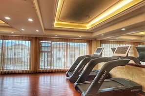 A gym with treadmills, large windows, and a wooden floor. - Oukai'er Hotel (Tonglu)