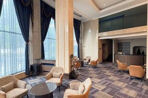 A hotel lobby with a check-in desk, seating area, and large windows. - Oukai'er Hotel (Tonglu)