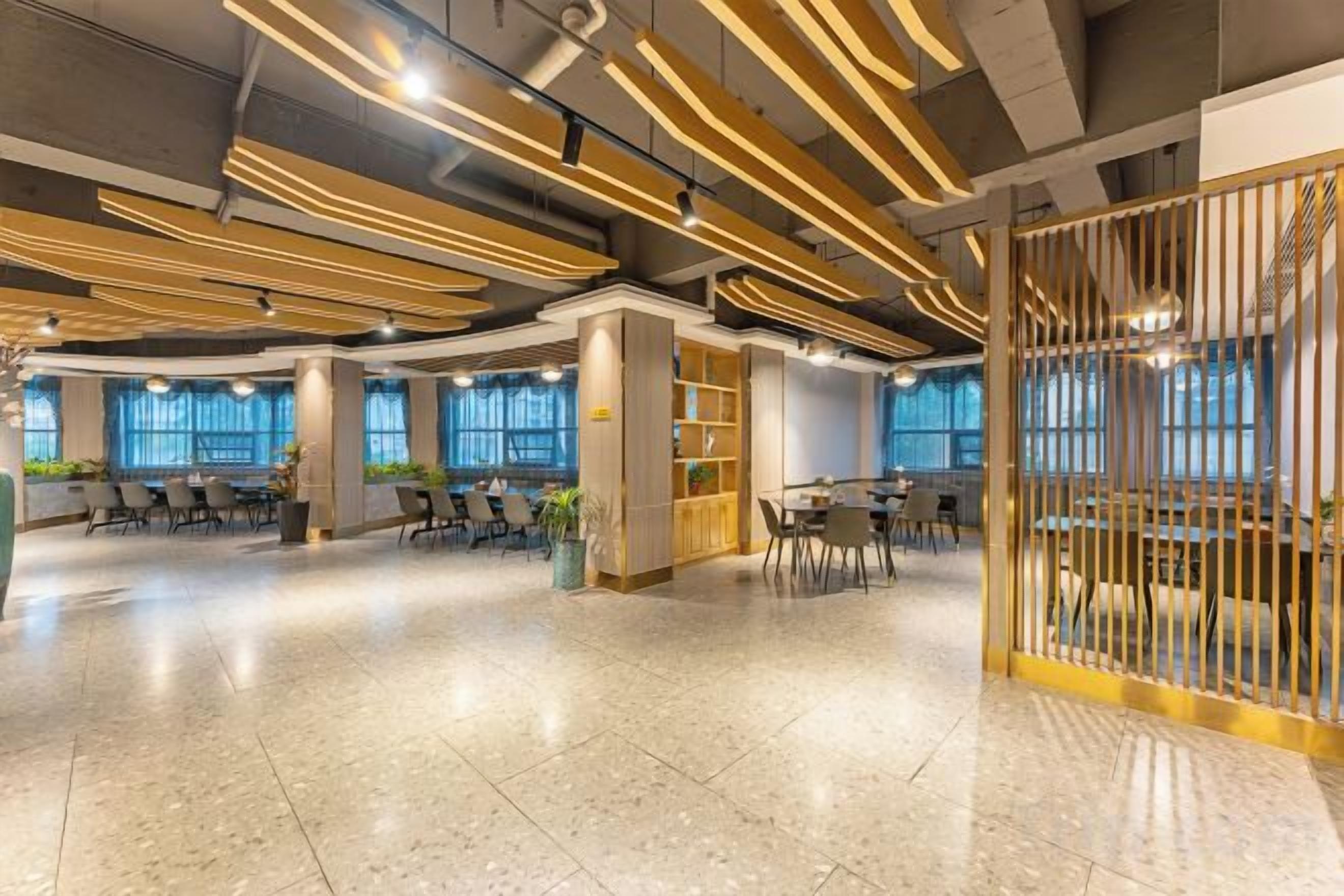 A spacious indoor area with multiple seating arrangements, a central column, and a decorative partition.