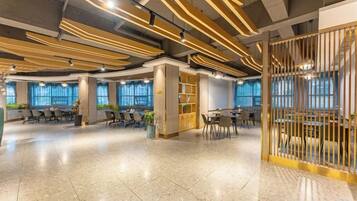 A spacious indoor area with multiple seating arrangements, a central column, and a decorative partition.