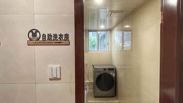 A laundromat with a sign, a washing machine, and a window.